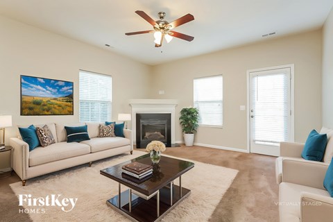 A living room with a fireplace, a couch, a coffee table, and a painting on the wall.