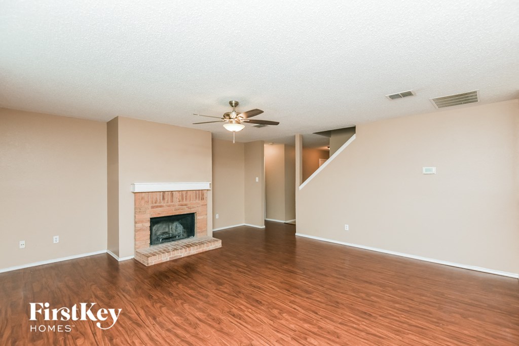 a living room with a fireplace and a ceiling fan