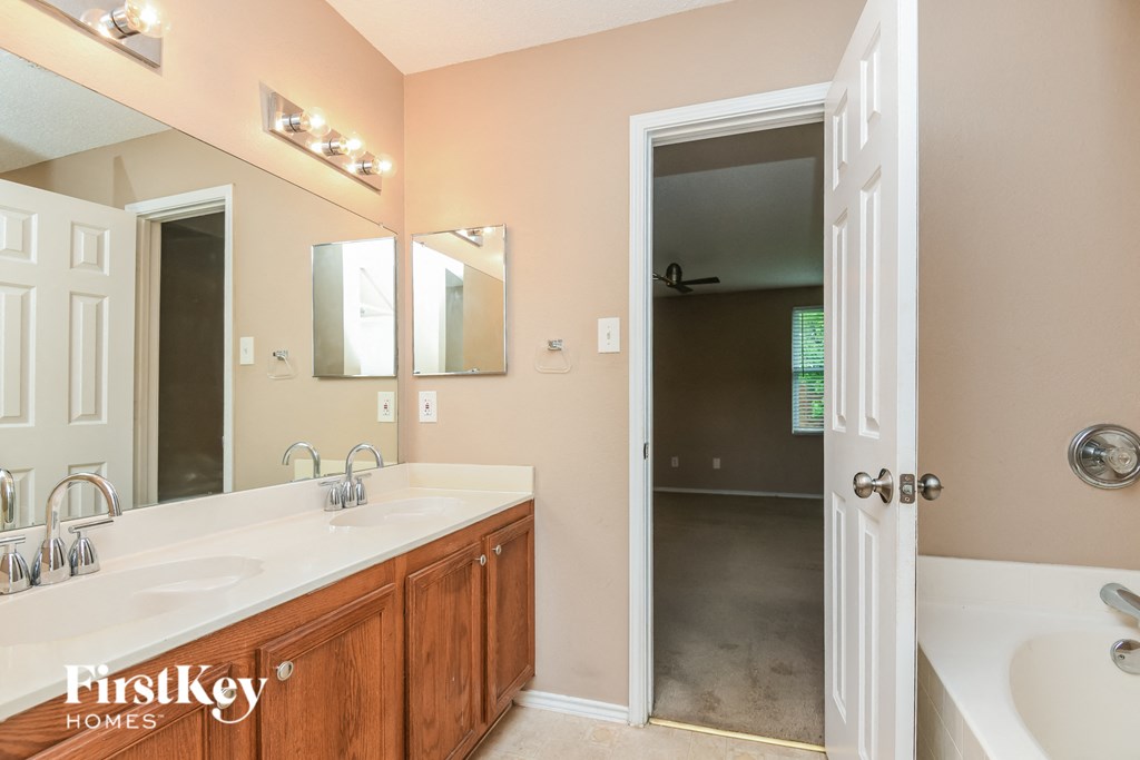a bathroom with two sinks and a tub and a mirror