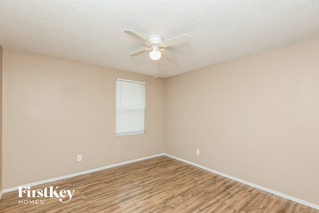 a bedroom with a ceiling fan and a hard wood floor