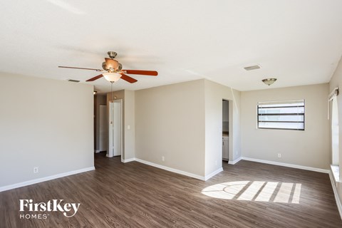 A room with a ceiling fan and wooden flooring.
