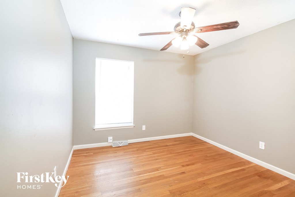a living room with wood floors and a ceiling fan