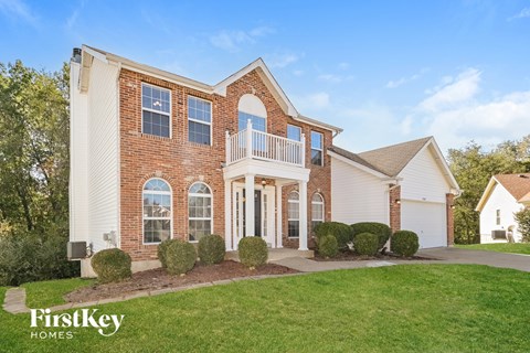 A brick house with a white porch and a sign that says "FirstKey Homes".