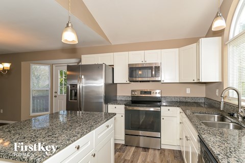 A kitchen with granite countertops and stainless steel appliances.