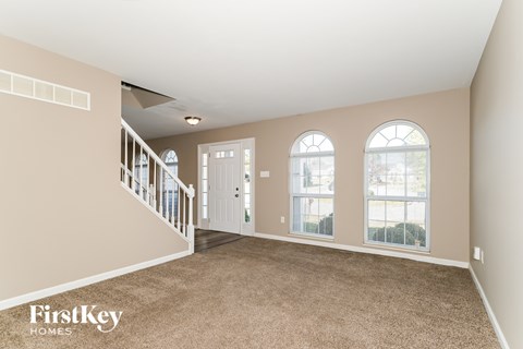 A spacious room with a staircase leading to the upper level.