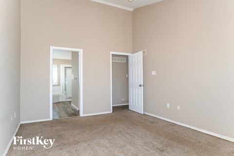 A room with a carpeted floor and two open doors.