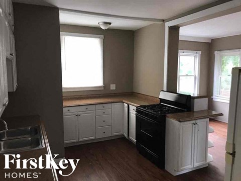 a kitchen with white cabinets and a stove and a sink