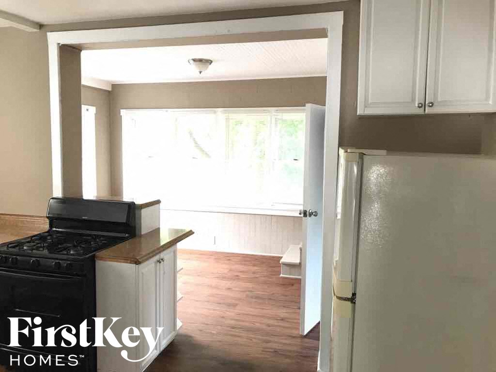 an empty kitchen with a stove and a refrigerator