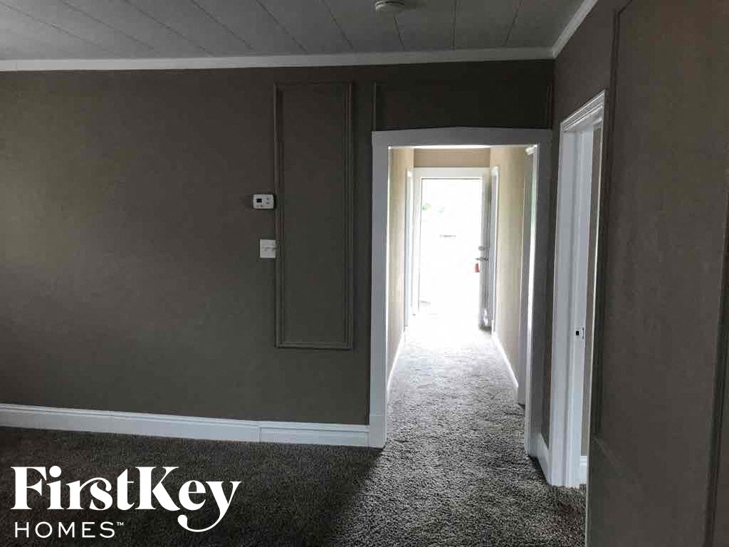 a dark room with a hallway and a door to a room