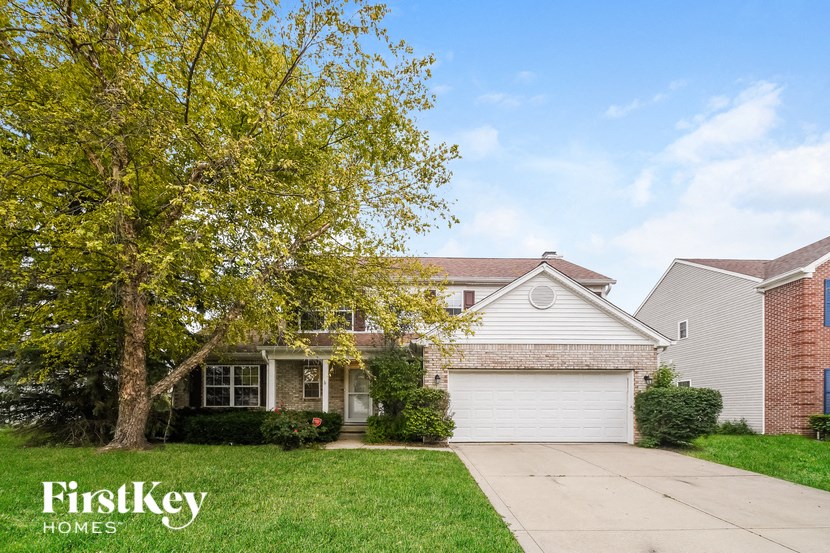 a white house with a tree in front of it