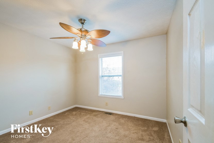 a bedroom with a ceiling fan and a window