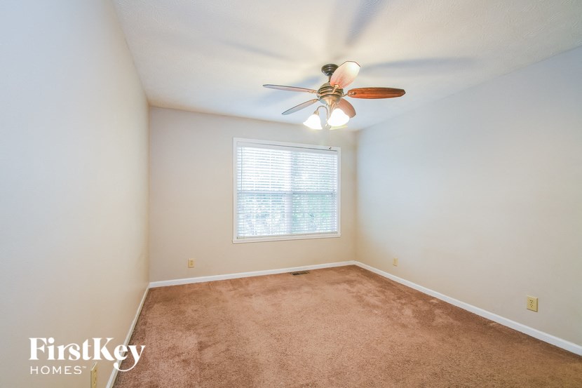 an empty room with a ceiling fan and a window