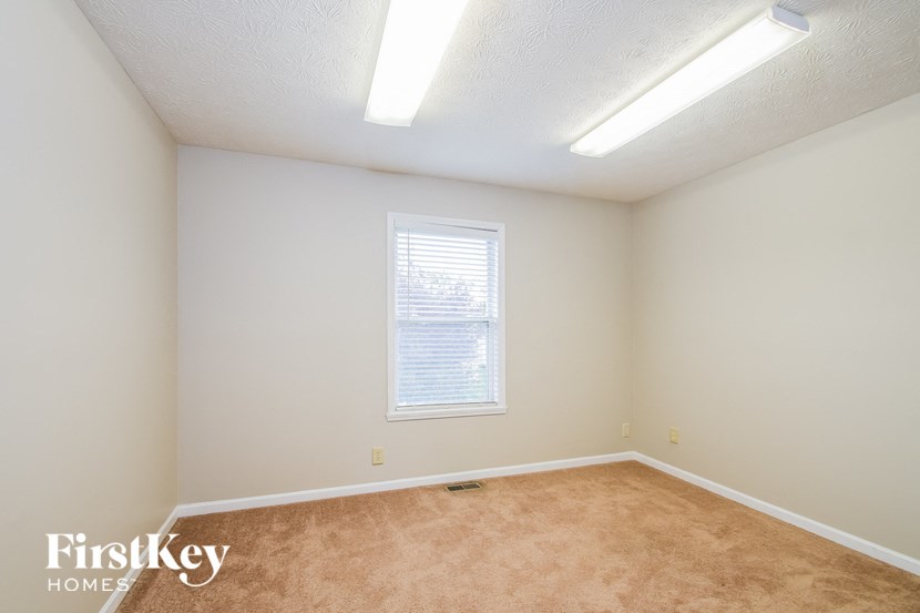 a bedroom with a carpeted floor and a window