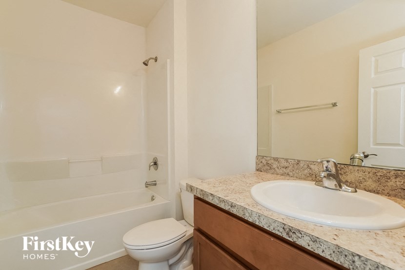 A bathroom with a toilet, sink and bathtub.