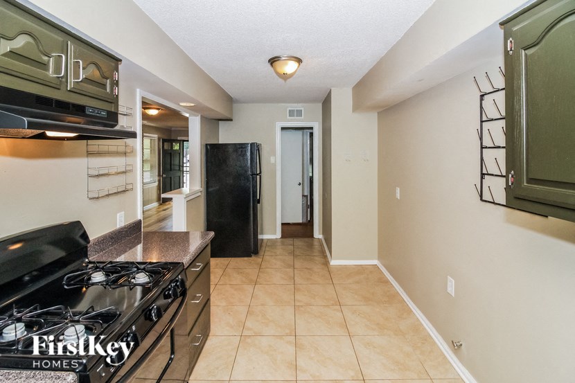 a kitchen with a stove and a refrigerator in a house
