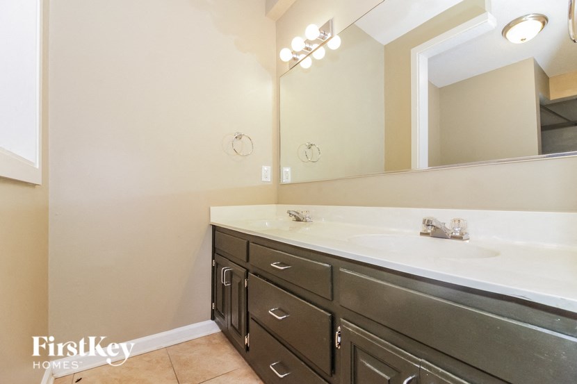 a bathroom with a sink and a mirror and a large mirror