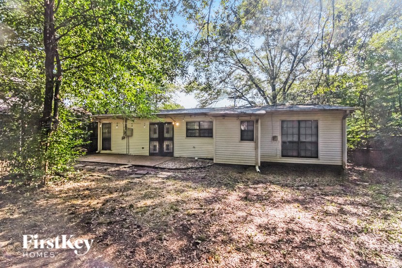 a small yellow house in the middle of the woods