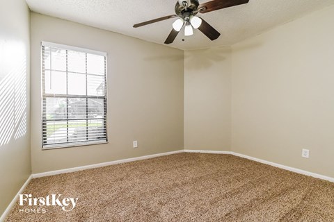 a bedroom with a ceiling fan and a window