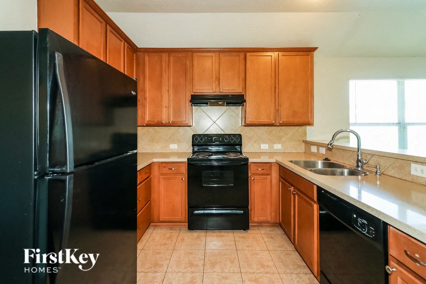 a kitchen with black appliances and wooden cabinets
