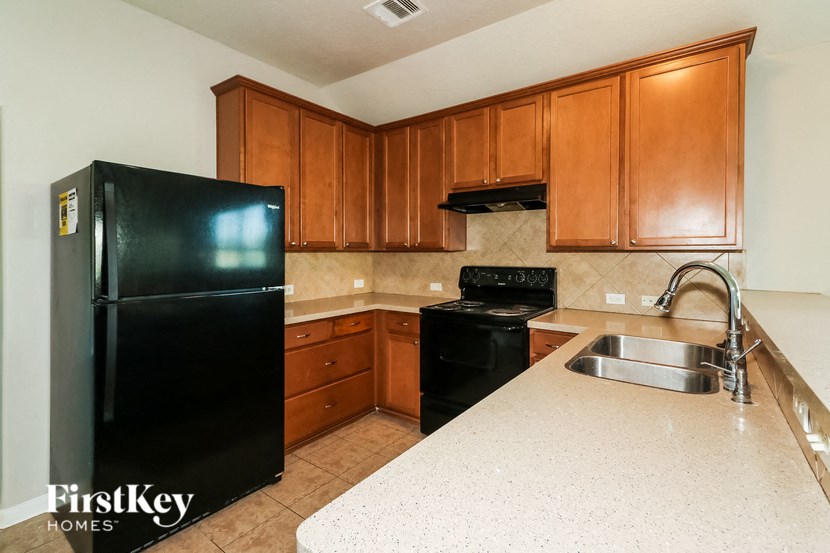 a kitchen with a black refrigerator and a sink