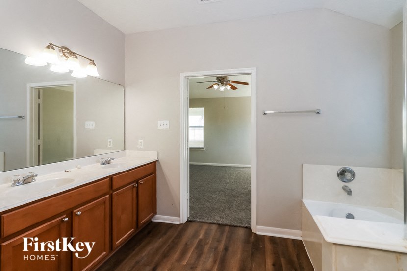 a bathroom with a tub and a sink and a mirror