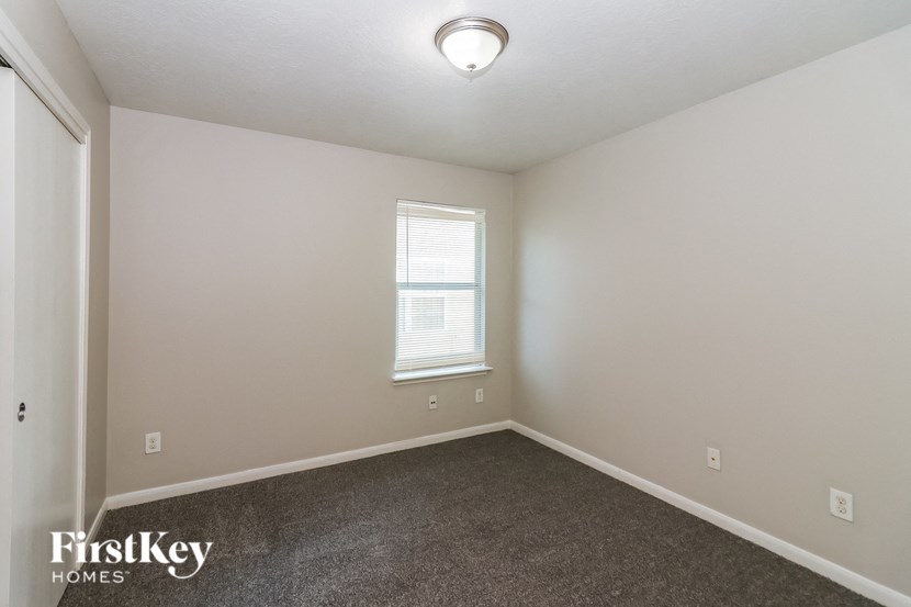 the living room of a home with carpet and a window