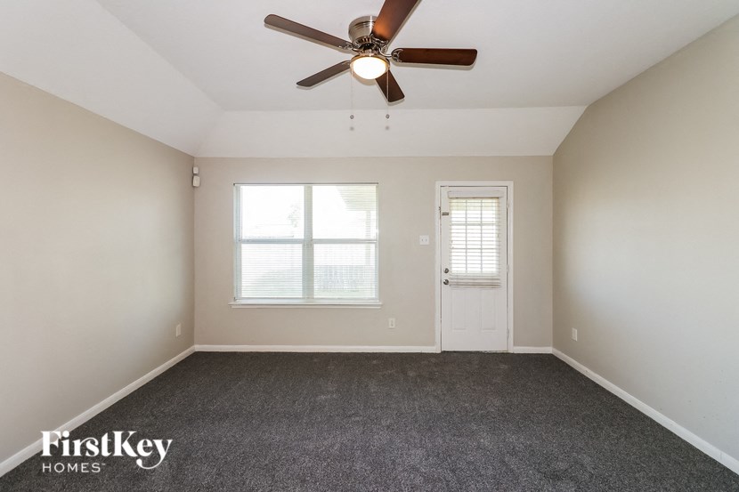 an empty room with a ceiling fan and a window