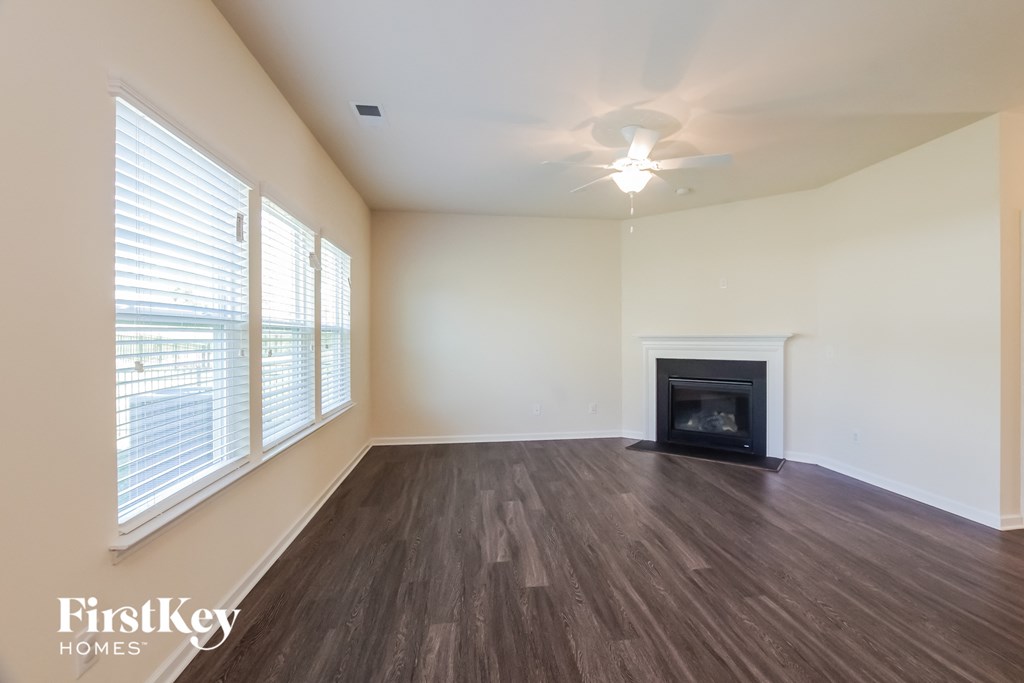 an empty living room with a fireplace and a large window