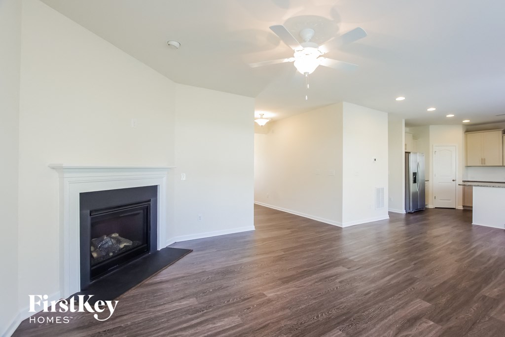 a living room with a fireplace and a ceiling fan