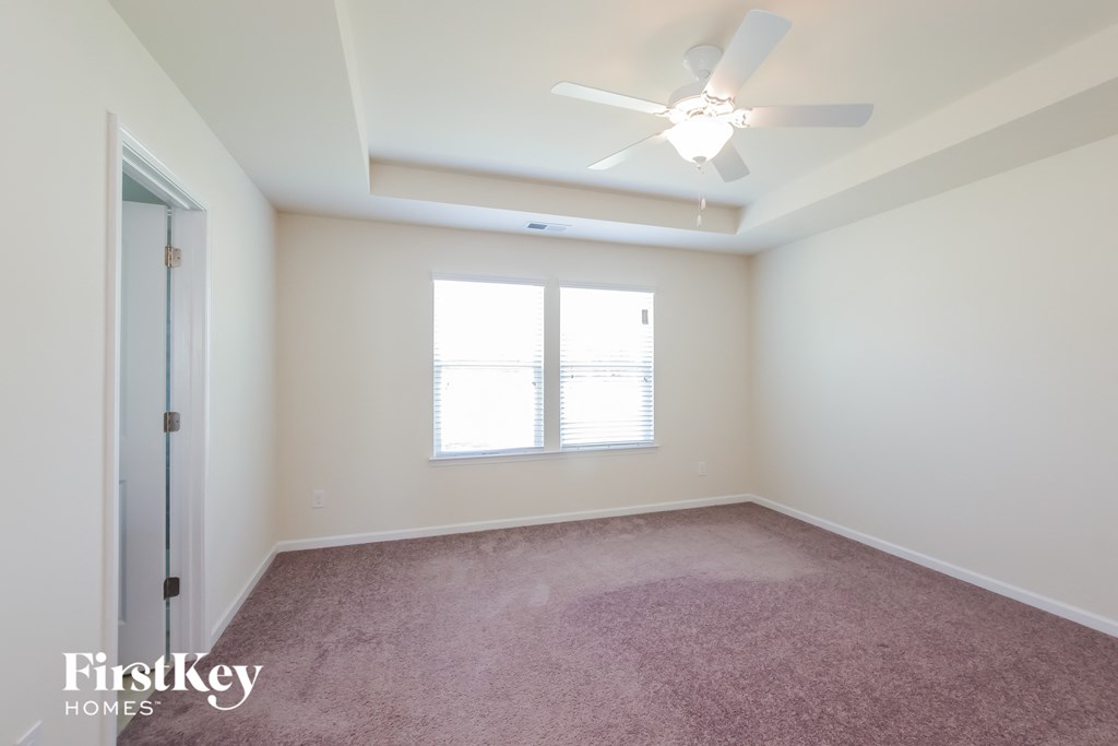 a bedroom with a ceiling fan and a window