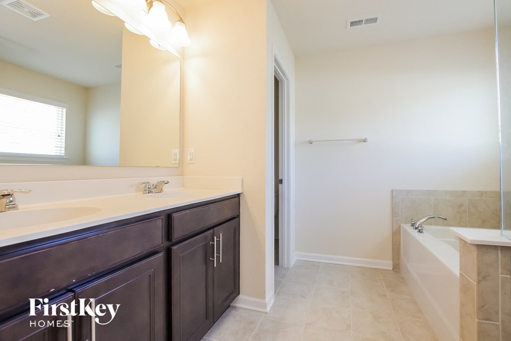 a bathroom with a large mirror and a sink and a tub