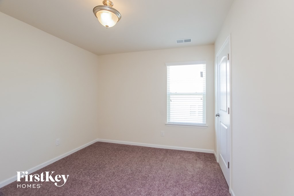 a bedroom with a carpeted floor and a white door