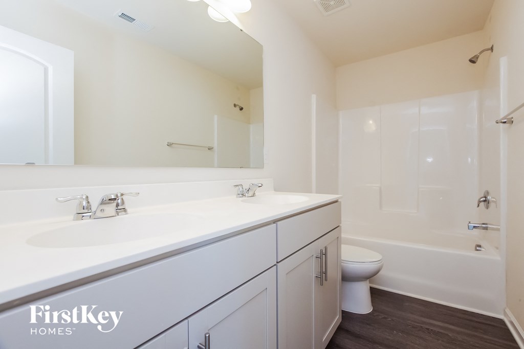 a bathroom with a white sink and a toilet and a shower