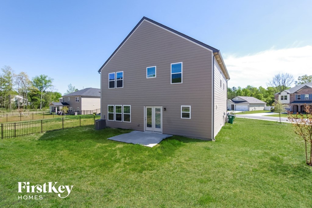 a gray house with white windows and a yard