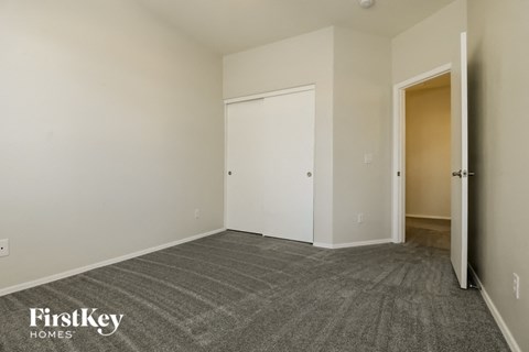 a bedroom with a carpeted floor and a door to a closet