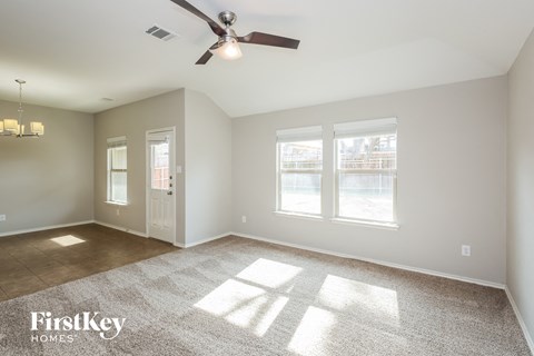 a living room with a ceiling fan and a window