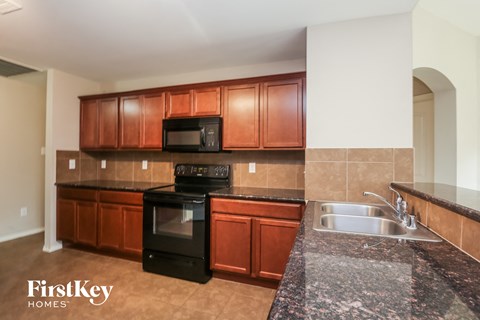 a kitchen with granite counter tops and wooden cabinets