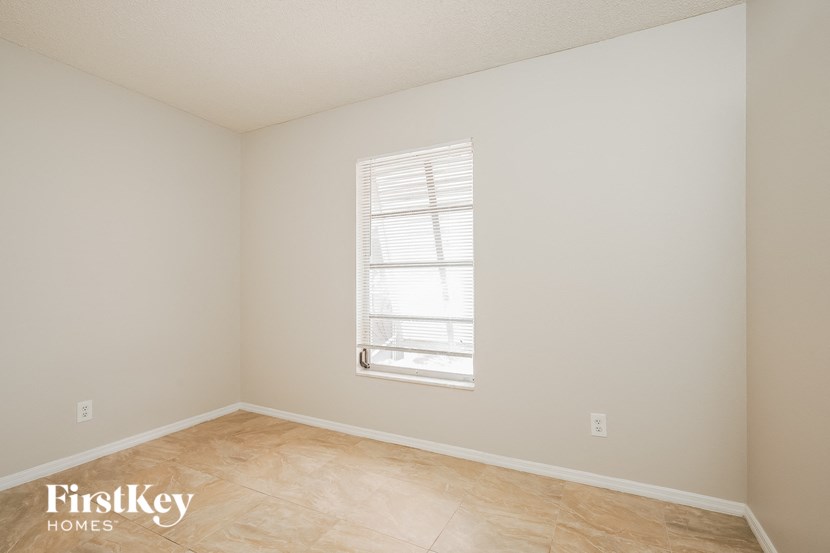 A room with a window and wooden flooring.