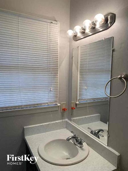 a bathroom with a sink and a mirror and a window