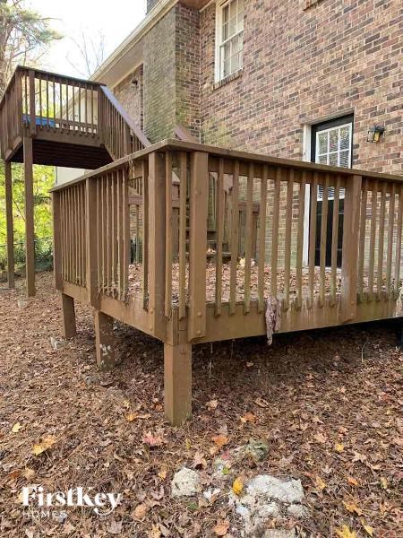 a wooden deck in front of a brick building