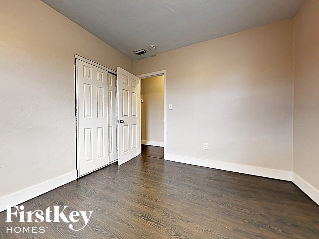 A room with a door and a wall with a switch.