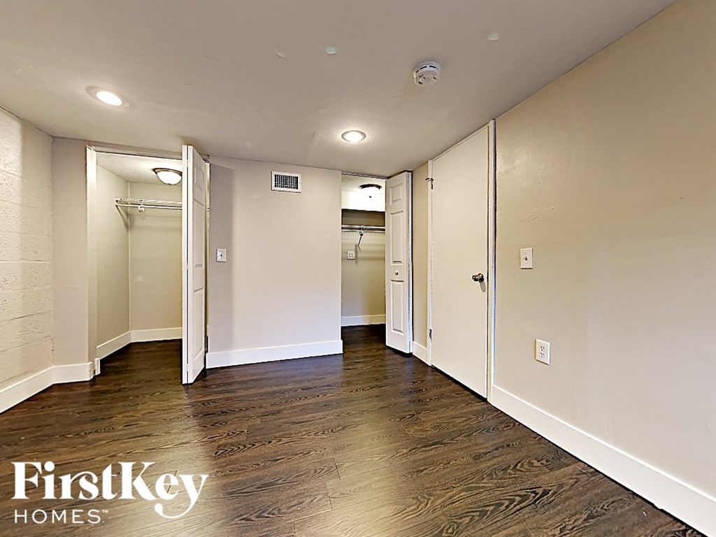A hallway with wood flooring and white walls.