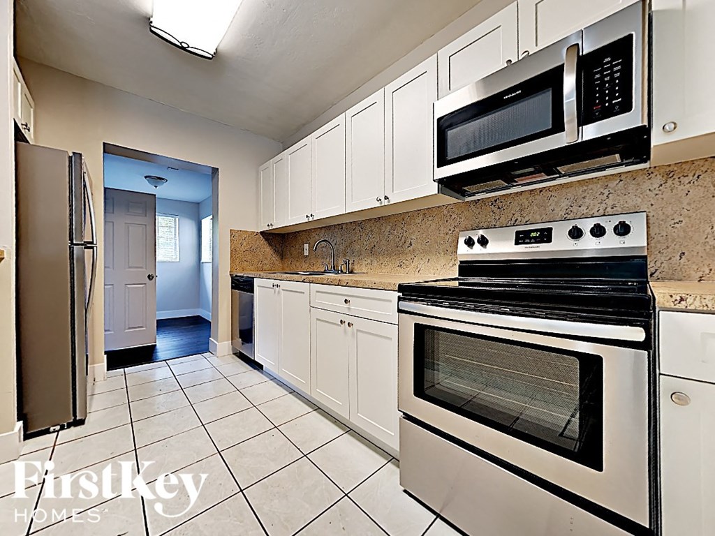 A kitchen with a stove top oven and microwave above it.