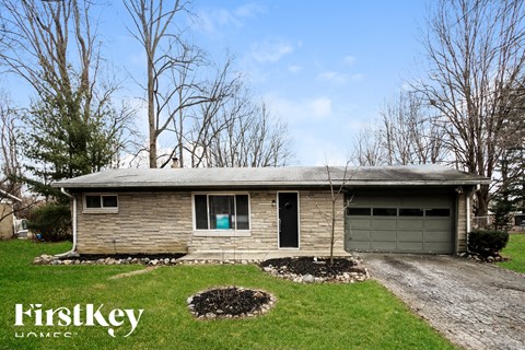 A house with a garage and a driveway in front of it.