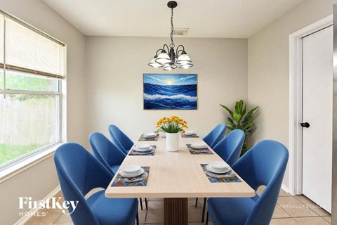 A dining room with a wooden table and blue chairs.