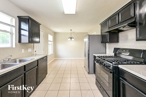 A kitchen with black appliances and cabinets is for sale.