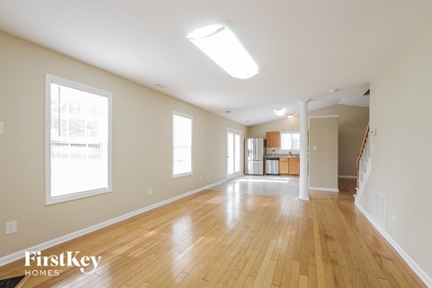A spacious room with wooden floors and skylight.