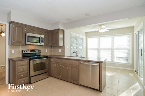 A kitchen with a stove top oven and a microwave above it.
