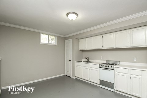 A kitchen with white cabinets and a stove top oven.