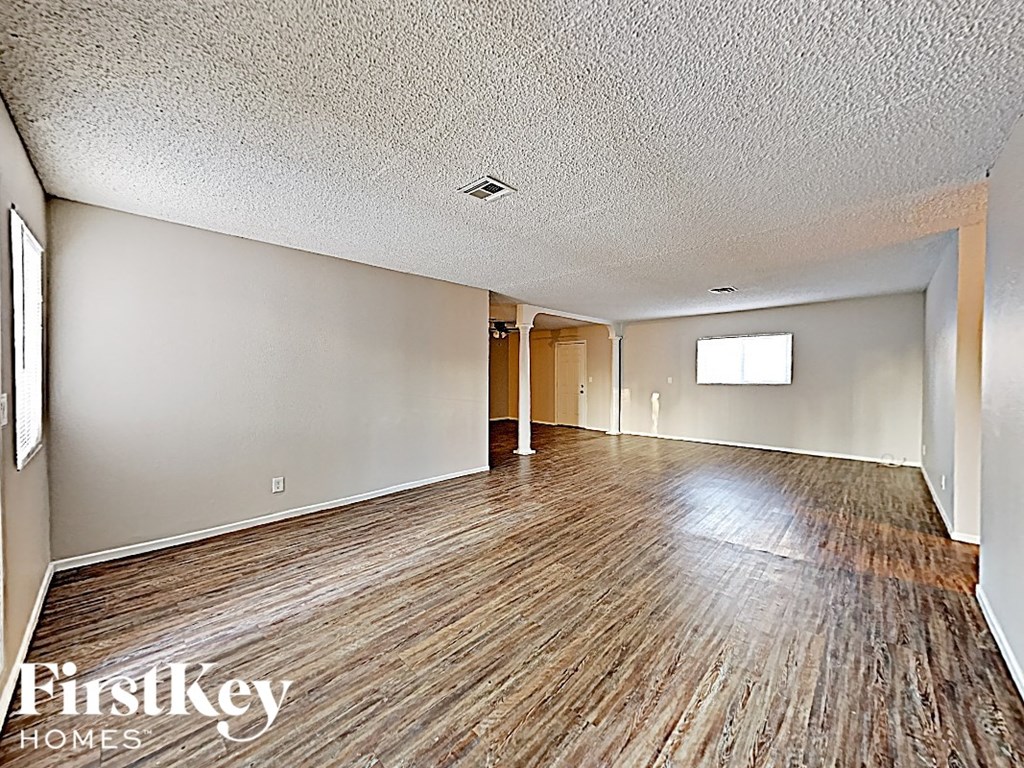 A room with wooden flooring and a window.